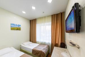 um quarto de hotel com duas camas e uma televisão de ecrã plano em Petrozavodsk Hotel em Petrozavodsk