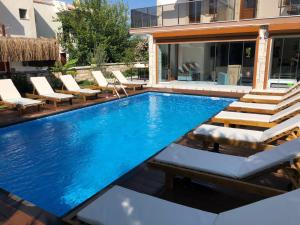 una piscina con sillas y una casa en Cesmeli Boutique Hotel - Çeşme, İzmir en Cesme