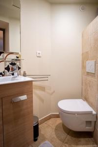 a bathroom with a toilet and a sink at Le Relais du Clocher in Irigny