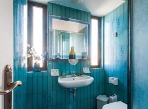 a blue bathroom with a sink and a toilet at Luxury Athenian Riviera Apartment 135 sqm at Voula in Athens