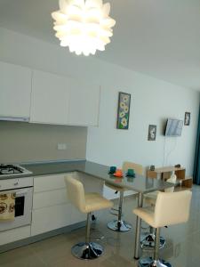 Una cocina con una mesa y sillas y una lámpara de araña. en BLUE apartment in 5* Ceasar Resort, en Trikomo