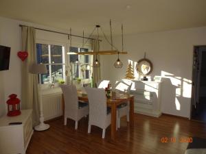 a dining room with a table and chairs and a window at Fewo Schröder - Harzblick in Braunlage