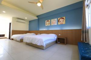 1 dormitorio con 2 camas y pared azul en Star House, en Jinning