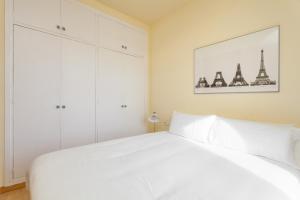 un dormitorio blanco con una cama blanca y algunos edificios en Penthouse Camp Nou, en Barcelona