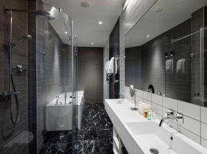 a bathroom with a sink, mirror, and bathtub at Upper House in Gothenburg