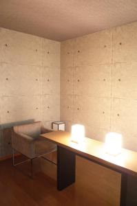 ein Zimmer mit einem Schreibtisch, einem Stuhl und zwei Lampen in der Unterkunft LUXe in Higashihiroshima