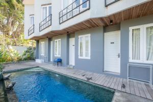 a swimming pool in front of a house at RedDoorz @ Pecatu Ungasan in Uluwatu