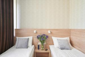 a room with two beds and a vase of flowers at Hotel Druzhba in Kyiv