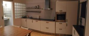 プラハにあるModern Apartment Perlovaの白いキャビネットと木製テーブル付きのキッチン