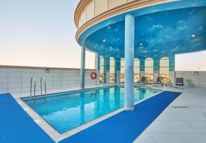 a large swimming pool in a building at TIME Express Hotel Al Khan in Sharjah