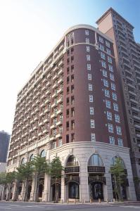 a large brown building with trees in front of it at Fullon Hotel Taoyuan in Taoyuan