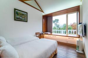 Rúm í herbergi á 逢春園Feng Chun Villa