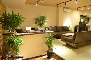 a living room with potted plants and a couch at Hilo Hostel in Nara