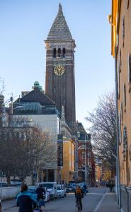 uma torre de relógio alta com um relógio em uma cidade em First Hotel Central em Norrköping