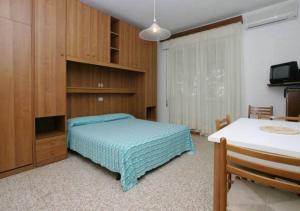 1 dormitorio con 1 cama, TV y mesa en Villa al Mare Camping-Village - 4 Stelle, en Cavallino-Treporti