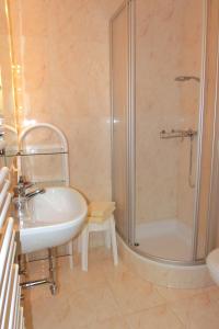 a bathroom with a shower and a sink and a tub at RUTH Haus KMB Seeblickappartement direkt am Ossiacher See mit Hallenbad Skiarena Gerlitzen in Bodensdorf