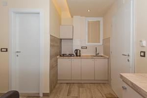 a kitchen with white cabinets and a counter top at Bitrak Guest House in Ohrid