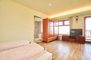 a bedroom with a bed and a television in a room at First Shanhai Hotel in Toucheng