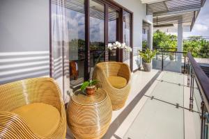 eine Veranda mit Stühlen und Vasen auf dem Balkon in der Unterkunft Villa Cascade in Seminyak