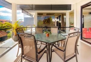 a dining room with a glass table and chairs at Villa Cascade in Seminyak