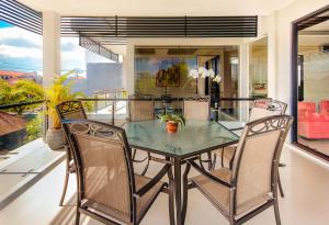 ein Esszimmer mit einem Glastisch und Stühlen in der Unterkunft Villa Cascade in Seminyak