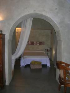una camera con un letto ad arco e un tavolo di La Magnifica a Pantelleria