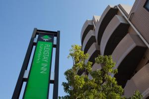 东京FLEXSTAY 巢鸭旅馆的建筑前的绿色标志