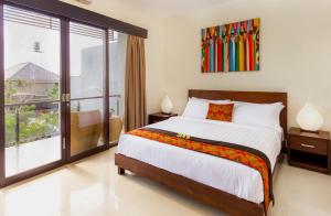 ein Schlafzimmer mit großem Bett und Balkon in der Unterkunft Villa Cascade in Seminyak + 17 Fotos