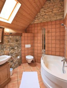 ein Bad mit einer Badewanne und einem WC in der Unterkunft Hotel Weingewolbe in Bermersheim