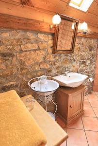 Baño de piedra con lavabo y espejo en Hotel Weingewolbe en Bermersheim