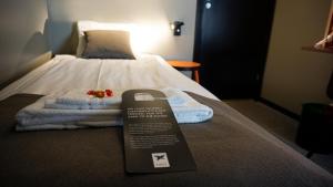 um quarto de hotel com uma cama com uma placa em First Hotel Central em Norrköping