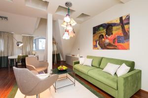 a living room with a green couch and a painting at Empirent Boutique Apartments in Prague