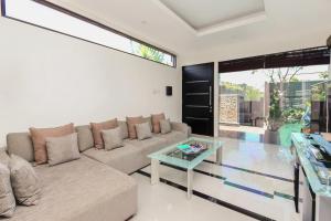 ein Wohnzimmer mit einer Couch und einem Glastisch in der Unterkunft Villa Cascade in Seminyak