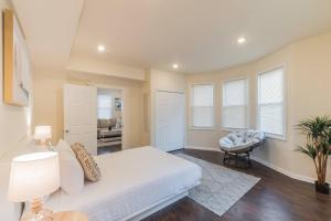 a bedroom with a white bed and a chair at 2 Blocks from Beach-Sleeps 16 in Ventnor City