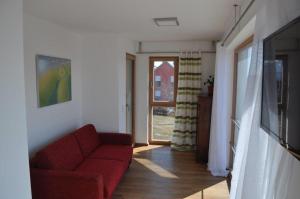 a living room with a red couch and a window at Designerhaus mit Dachterrasse in Nittendorf