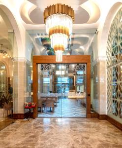 a lobby with a chandelier and a dining area at The Radh Hotel in Kandy