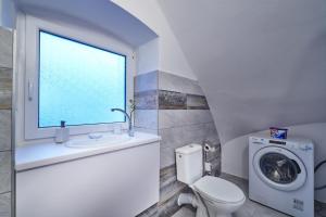 a bathroom with a toilet and a sink and a window at Apartmán BB centrum in Banská Bystrica