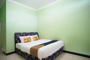 Cama ou camas em um quarto em SPOT ON 2729 Marzan Syariah Guest House