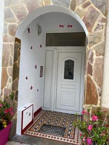 una entrada a una puerta blanca con una pared de piedra en christiane cere, en Amélie-les-Bains-Palalda
