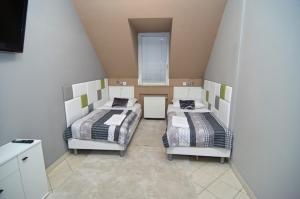 a room with two beds and a window at Soda apartman in Győr