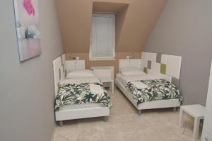 a room with two beds and a window at Soda apartman in Győr