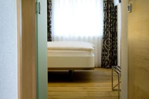a bed in a room with a window at Hôtel-Restaurant du Cerf in Sonceboz