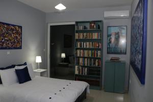 een slaapkamer met een bed en een boekenplank gevuld met boeken bij Laconian Collection "Lykourgou 10" in Sparta