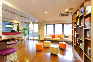 東京にあるホテルマイステイズ浅草の椅子、テーブル、ソファ付きの図書室