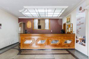 uma sala de tribunal com um banco de madeira e um espelho em Hotel Líder - By UP Hotel em Timóteo