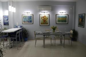 comedor con mesa, sillas y pinturas en Laconian Collection "Lykourgou 10" en Sparti