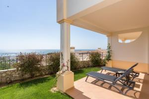 a patio with a table and chairs and the ocean at NAU Salema Beach Village in Salema