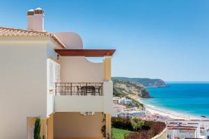 
a house with a balcony overlooking the ocean at Salema Beach Village in Salema
