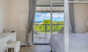 a bedroom with a bed and a view of the ocean at West Rock Villas in Saint James +37 photos