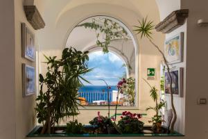 an arched window with plants in a room with a view at Hotel Marina Riviera in Amalfi